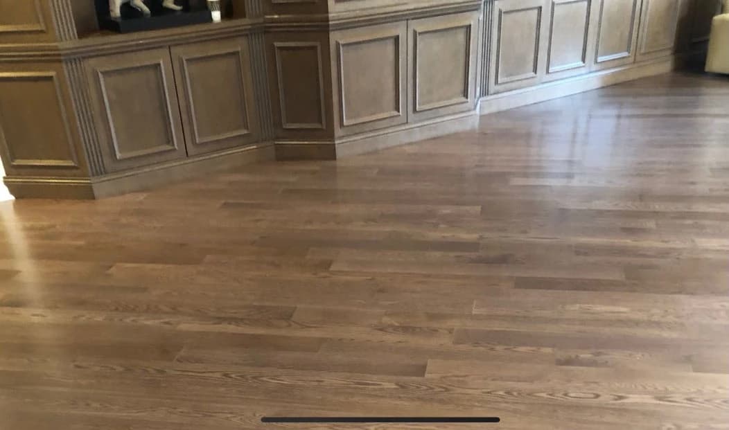 A warm wood plank floor next to pale built-in cabinetry in the Highland Park condominium.