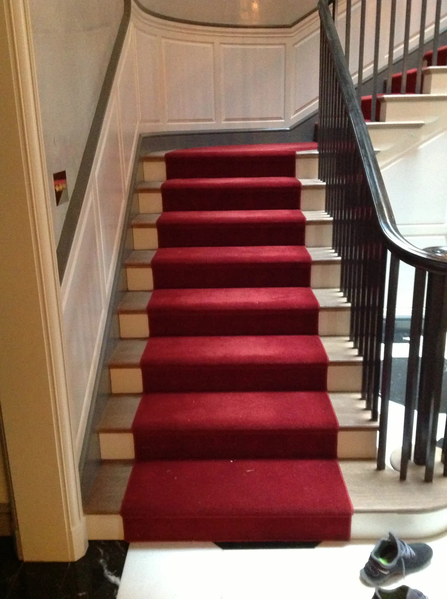 Lincoln Park staircase with a red runner and dark handrail.